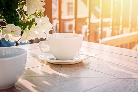 White big cup of delicious coffee on wooden table in sunset light with copy space. Lifestyle view.の写真素材