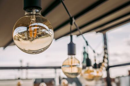 Decorative vintage sphere lamps in a row hanging from ceiling in cafe. Close up.の写真素材