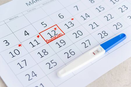 Negative pregnancy test with circling date in calendar. Planning of pregnancy, trying to have baby.の写真素材