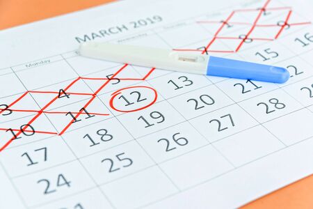 Pregnancy test with circling date in calendar. Planning of pregnancy, trying to have baby.の写真素材