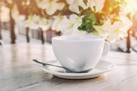 White big cup of delicious coffee on wooden table in sunset light with copy space. Lifestyle view.の写真素材
