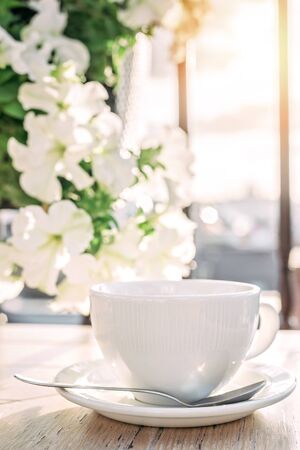 White big cup of delicious coffee on wooden table in sunset light with copy space. Lifestyle view.の写真素材