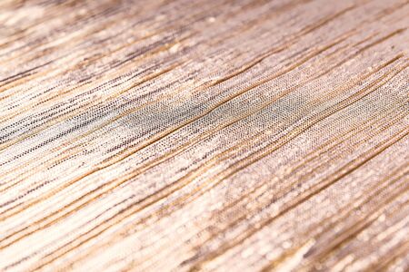 Golden shiny striped fabric, abstract background. Close-up.の写真素材