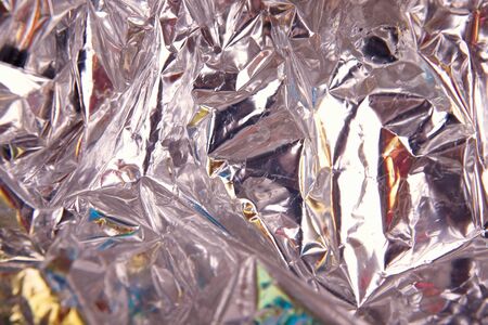 Crumpled silver paper with holographic and chameleon effect. Close up.の写真素材