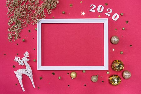 Festive christmas frame made of golden balls, fir tree branches, decorations and confetti on pastel pink background with copy space. Flat lay, top view. Christmas, winter, New Year concept.の写真素材