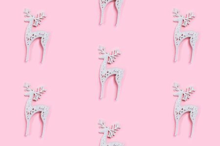 Pattern made of white christmas deer decoration on pastel pink background. Christmas concept. Flat lay, top view.の写真素材