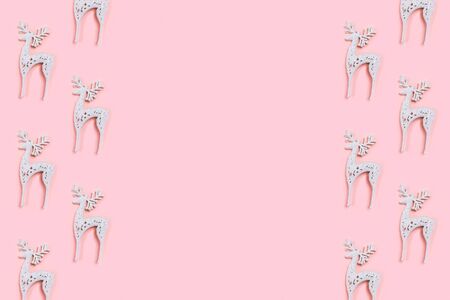 Pattern made of white christmas deer decoration on pastel pink background. Christmas concept. Flat lay, top view.の写真素材