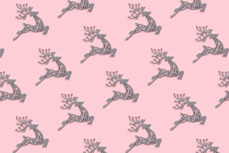 Pattern made of white christmas deer decoration on pastel pink background. Christmas concept. Flat lay, top view.の写真素材