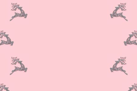 Pattern made of white christmas deer decoration on pastel pink background. Christmas concept. Flat lay, top view.の写真素材