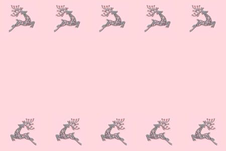 Pattern made of white christmas deer decoration on pastel pink background. Christmas concept. Flat lay, top view.の写真素材