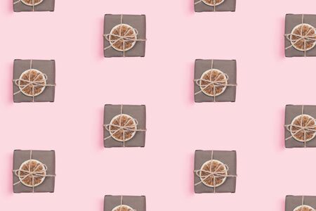 Pattern made of presents wrapped in craft paper with dried orange slice decoration. Holiday zero waste concept. Flat lay, copy space.の写真素材