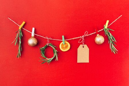 Christmas handmade garland made of 2020 wooden numerals and fir tree branches and other christmas decorations on red background. Christmas, New Year, zero waste concept.の写真素材