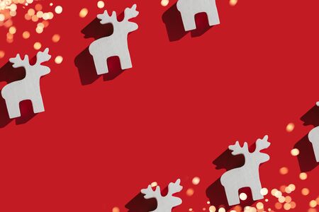 Frame pattern made of white wooden christmas deer decoration on red background. Christmas concept. Flat lay, top view.の写真素材