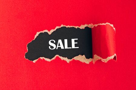 Wors sale on black background under torn red paper. Mockup, with copy space.の写真素材