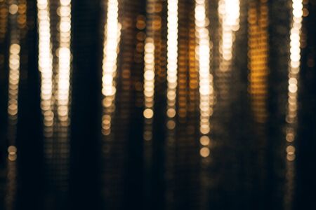 Golden shiny fabric with sequins, blured abstract background.の写真素材