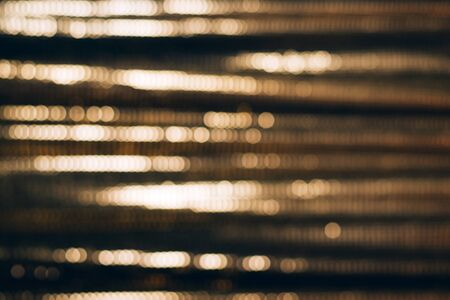 Golden shiny fabric with sequins, blured abstract background.の写真素材