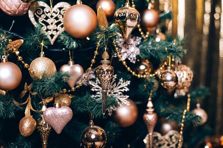 Fir branch with golden balls and festive lights on the dark background with sparkles.の写真素材