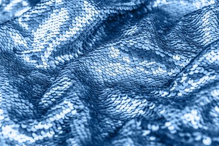 Shiny fabric with sequins, abstract background toned blue color. Close up, 2020.の写真素材