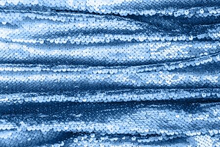 Shiny fabric with sequins, abstract background toned blue color. Close up, 2020.の写真素材
