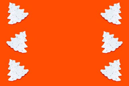 Pattern made of fir tree shaped ginger cookies on orange background. Christmas concept, 2020. Top view, flat lay.の写真素材