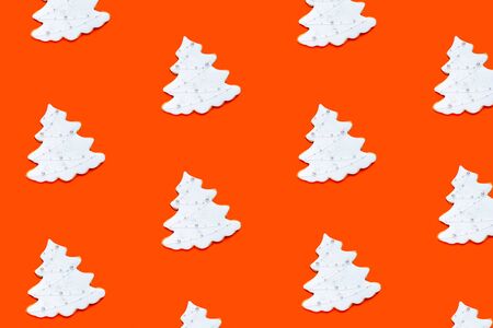 Pattern made of fir tree shaped ginger cookies on orange background. Christmas concept, 2020. Top view, flat lay.の写真素材