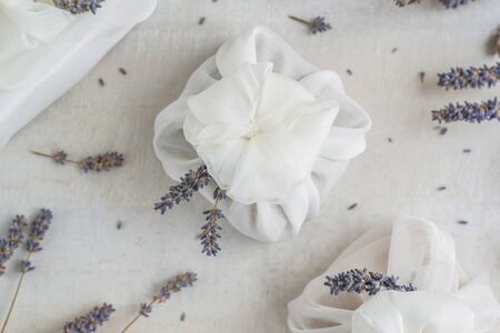 Present wrapped with white furoshiki fabric and decorated with lavender flowers. Eco friendly gift, zero waste concept.の写真素材