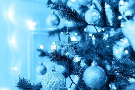 Christmas tree with toys in blue color. Decorated christmas tree toned blue color, 2020.の写真素材