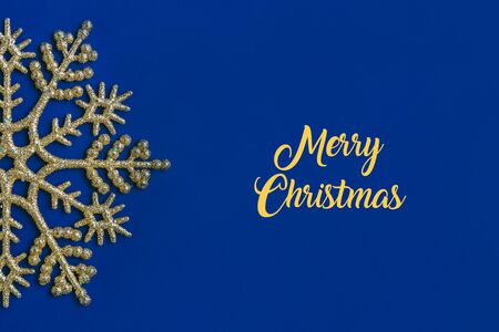 Golden snowflake christmas decoration on the blue background. New year greeting card. Holiday mock up.の写真素材