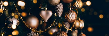 Banner with decorated christmas tree with golden toys on dark background. Christmas festive concept, 2020.の写真素材