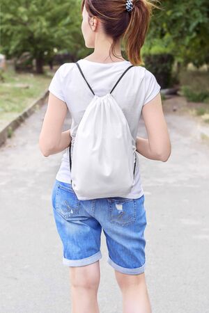 Woman with drawstring bag on the shoulder. Cropped.の写真素材