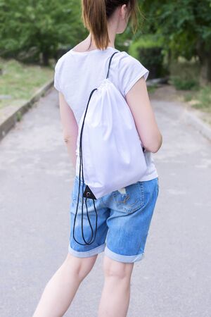 Woman with drawstring bag on the shoulder. Cropped.の写真素材
