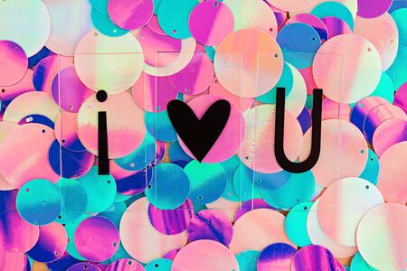 Background with shiny pink, purple and holographic sequins with words I love you, abstract background. Valentine's day card.の写真素材