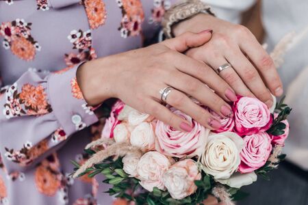 A romantic couple holding hands with wedding rings. Cropped.の写真素材