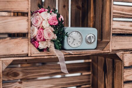 Wedding bouquet of pink and white roses near with retro alarm clock watches. Toned.の写真素材