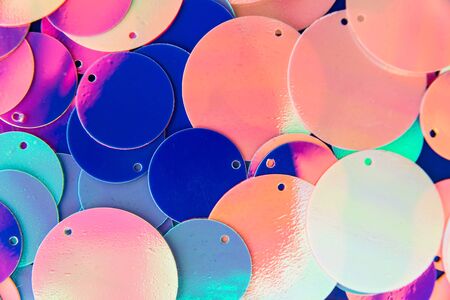 Big round holographic sequins abstract colorful background. Top view.