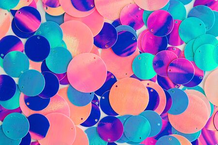 Big holographic sequins on pale orange background. Top view.の写真素材