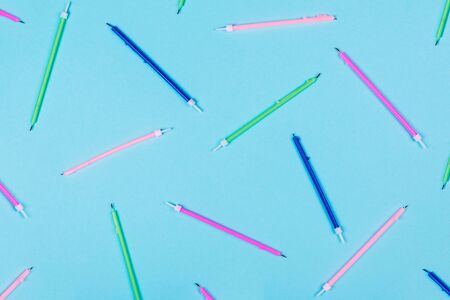 Pattern with colorful birthday candles on pastel blue background with copy space. Creative and moody picture. Top view.の写真素材