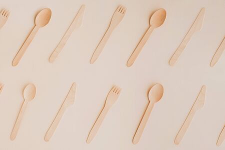 Wooden eco-friendly kitchenware pattern on pale background. Wooden spoons, knives and forks pattern, flat lay.の写真素材