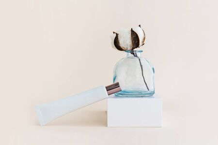 White tube of cream and cotton flower. Minimal organic and zero waste cosmetics concept. Monochrome.の写真素材