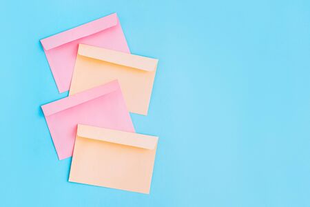 Colorful correspondence envelopes on blue background with copy space. Top view.