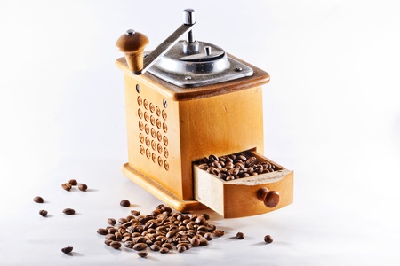 antique yellow wooden coffee mill full of coffee seedsの写真素材