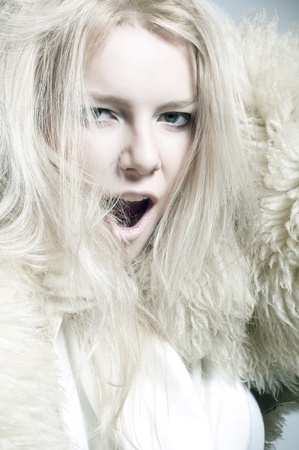 Charming blonde posing in furs isolated on white backgroundの写真素材