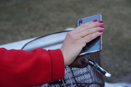 mobile phone in hand with red manicureの写真素材