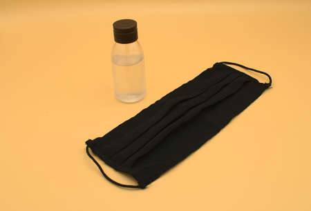 Small bottle of gel hand and black washable fabric face mask