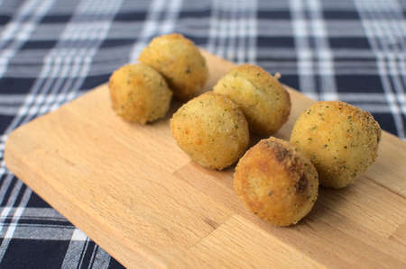 Close-up of appetizer of ham and parmesan cheese croquettes arranged two by two with a toothpick on...