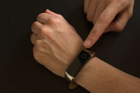 Close-up of woman using smart bracelet, woman hand