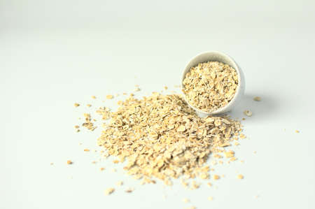 bowl, more oatmeal more oatmeal scattered on the table in high key pictureの写真素材