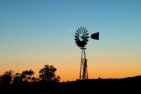 Windmill and moon at sunset.の写真素材