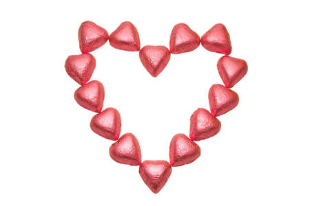 A heart shaped out of pink foil wrapped chocolate hearts. Isolated and with clipping path for easy...