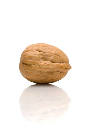A single walnut and its reflection against a white background.